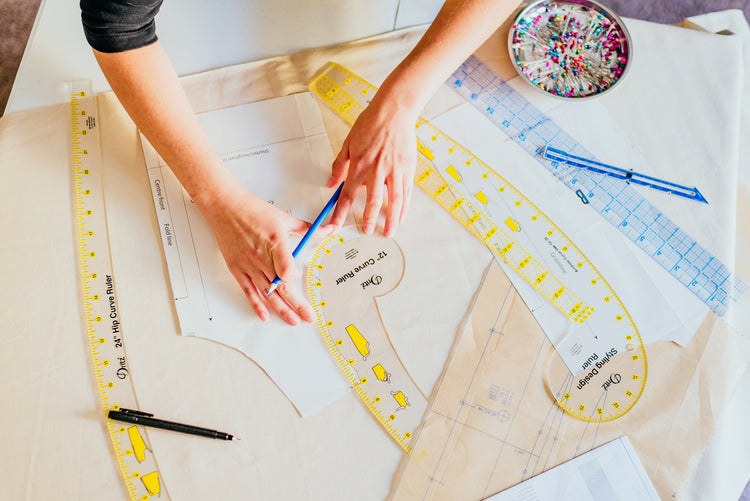 Person working with sewing patterns and tools on a table